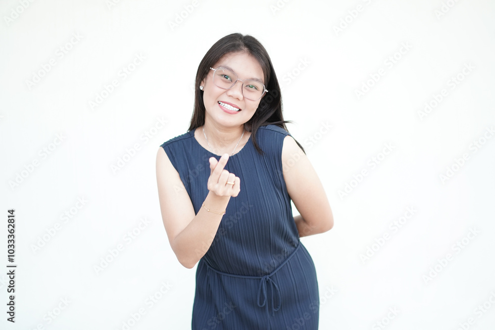 Beautiful Asian woman displays the Korean finger heart sign, radiating warmth against a white background Beautiful Asian woman displays the Korean finger heart sign, radiating warmth against a white background