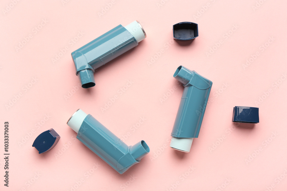 Inhalers and lids on pink background, closeup Inhalers and lids on pink background, closeup