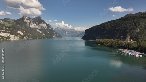 Village of Wessen with moored boats on Lake Walensee. Amazing natural scenery in the mountains of Switzerland. Aerial view photo