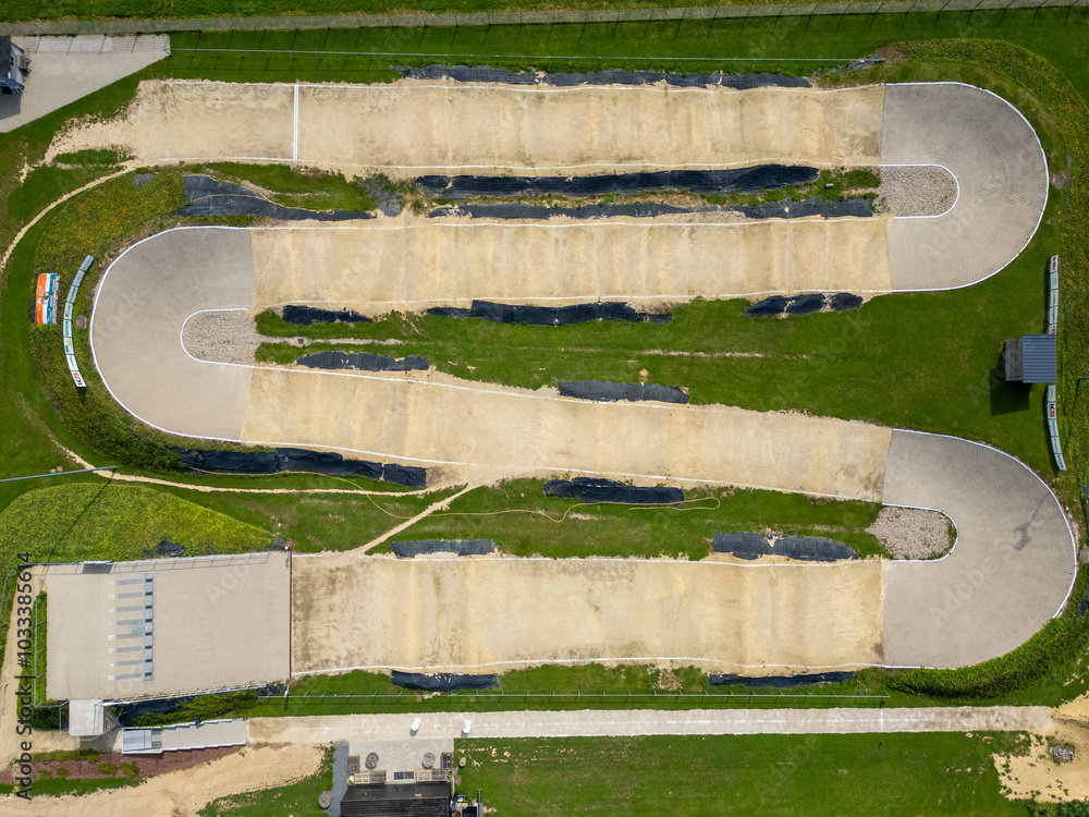 Naklejka premium An absolutely stunning aerial shot showcases a vibrant BMX racing track, featuring multiple curved paths