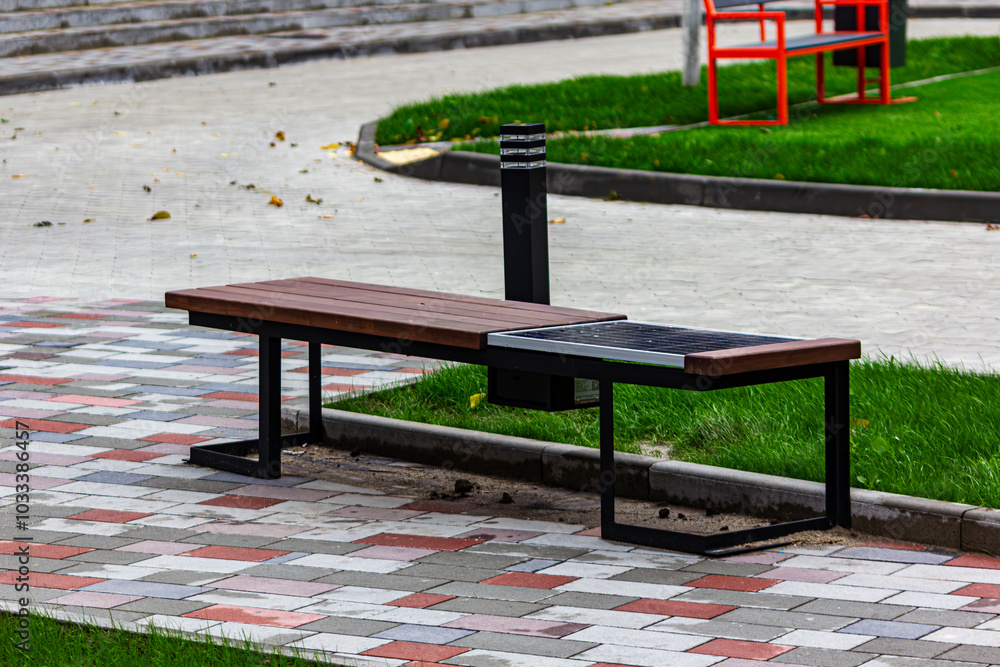 A bench with a solar panel. Conversion of solar energy in the park and street A bench with a solar panel. Conversion of solar energy in the park and street