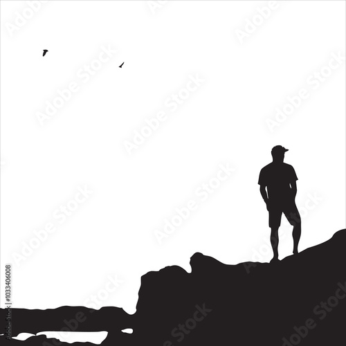 Silhouette of a man standing on rocks with birds flying in the sky.