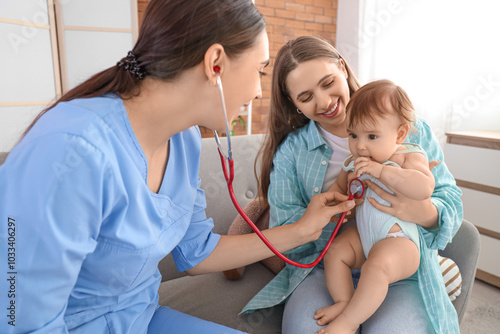 Female pediatrician with stethoscope listening to little baby and mother on s...