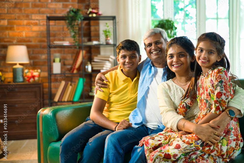 Obraz premium Cheerful Indian Asian family poses for a close-up photo while sitting on the sofa