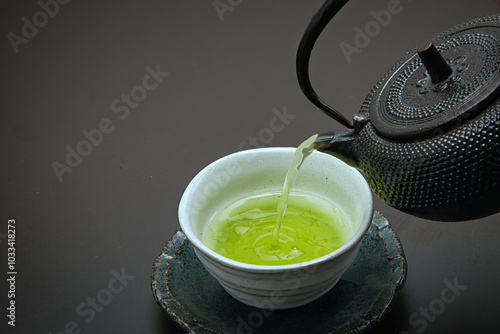 鉄でできた急須と茶碗に注がれた日本茶