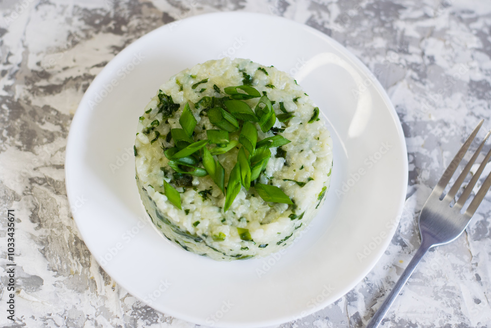 Vegan, vegetarian delicious dish. Rice with spinach on a white plate, flatlay. Concept of healthy eating Vegan, vegetarian delicious dish. Rice with spinach on a white plate, flatlay. Concept of healthy eating