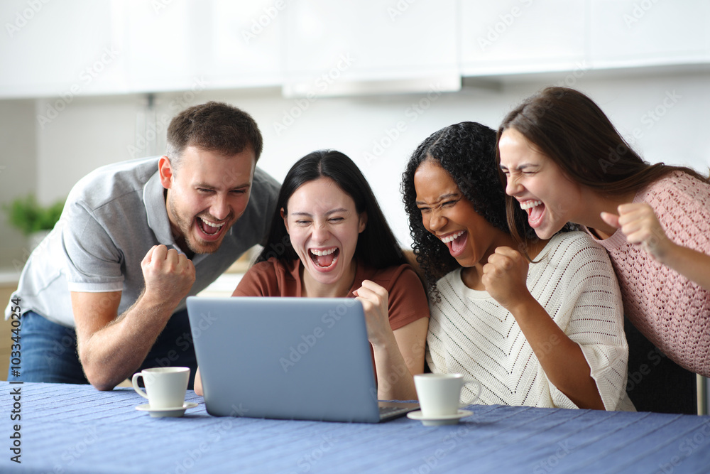 Four euphoric roommates celebrating checking laptop Four euphoric roommates celebrating checking laptop