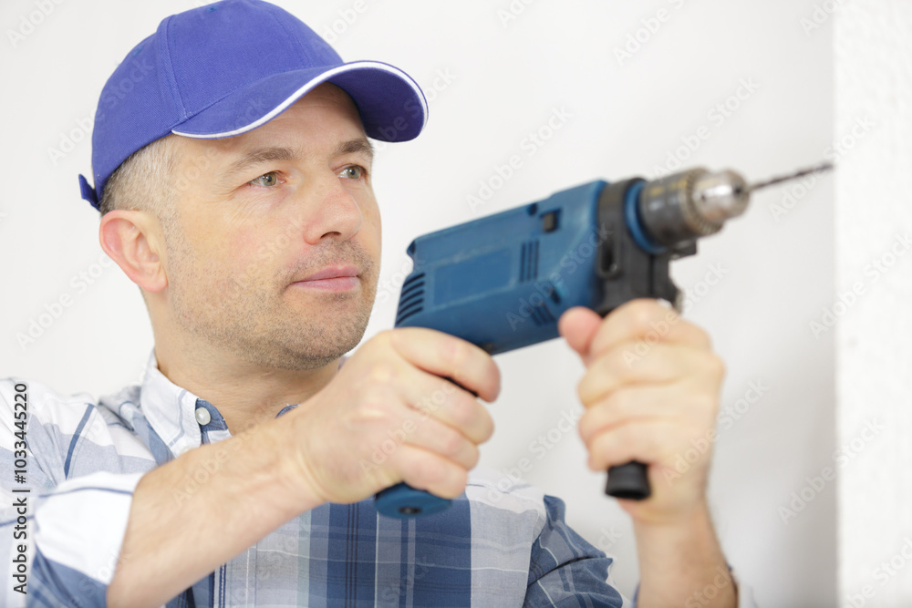 building worker with perforator drilling the wall indoors building worker with perforator drilling the wall indoors