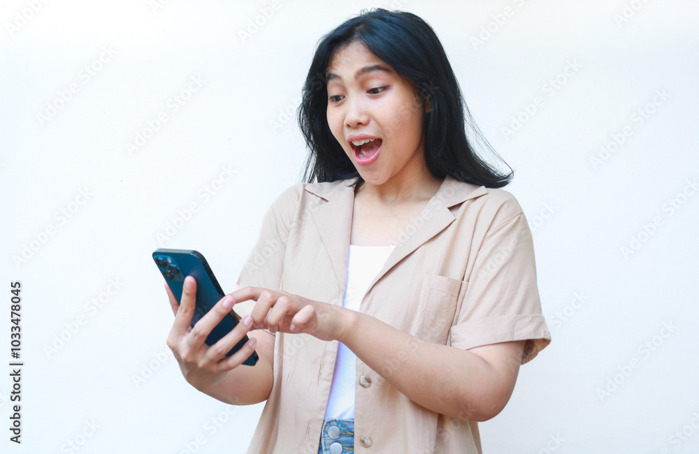 shocked asian woman holding smartphone looks amazed wearing casual clothes isolated on white background shocked asian woman holding smartphone looks amazed wearing casual clothes isolated on white background