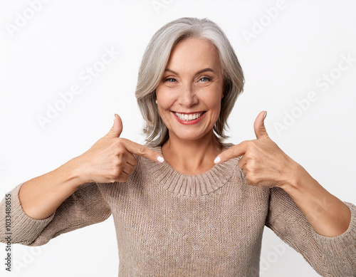 Mujer senior sonriente en actitud positiva con ademan de éxito y pulgares arriba photo