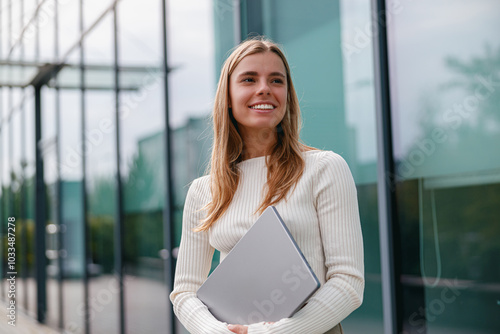 Confident Businesswoman Working on Her Laptop in a Bright, Modern Office Environment