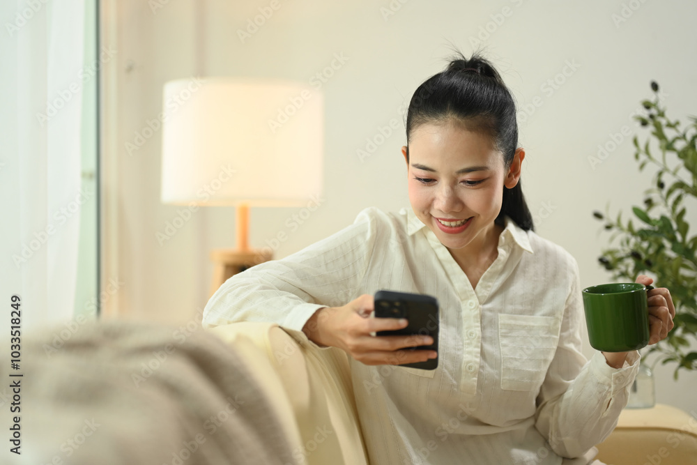 Happy young adult woman drinking coffee and checking her mobile phone Happy young adult woman drinking coffee and checking her mobile phone