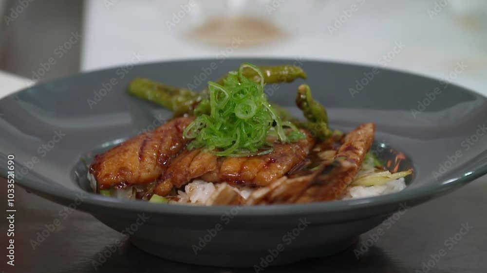 접시에 담긴 갈치 덮밥에 고명으로 파를 올리는 모습 접시에 담긴 갈치 덮밥에 고명으로 파를 올리는 모습