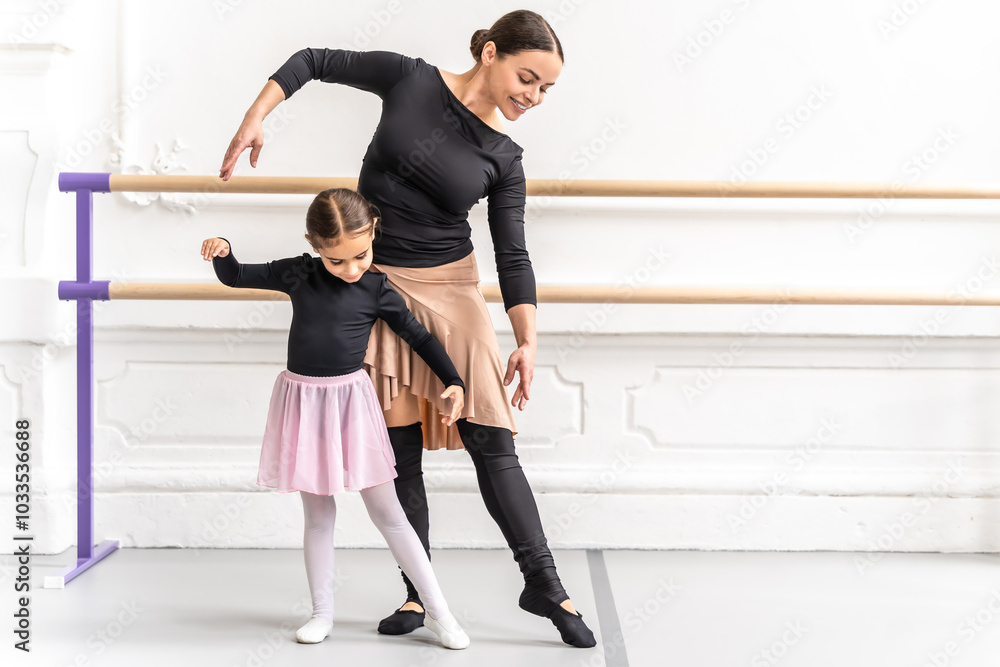 Graceful child and teacher dancing together in studio Graceful child and teacher dancing together in studio