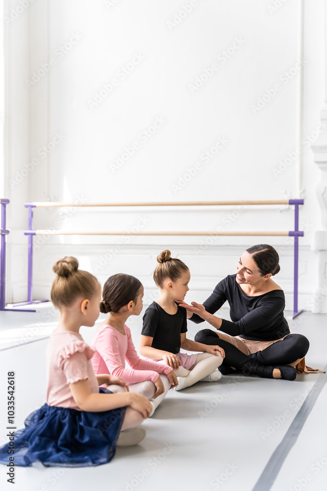 Woman with little ballerinas in cute skirt during ballet training in studio Woman with little ballerinas in cute skirt during ballet training in studio