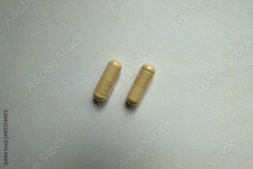 Two beige capsules of Saccharomyces boulardii probiotic dietary supplement from above photo