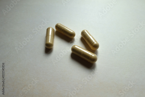 Four beige capsules of Saccharomyces boulardii probiotic dietary supplement photo