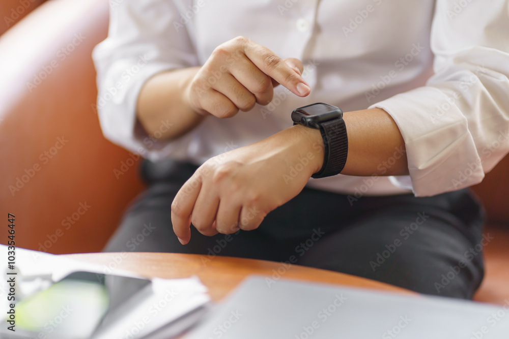 Fototapeta premium Business woman Looking at&nbsp;smart watch In Office online connect Gadget technology.