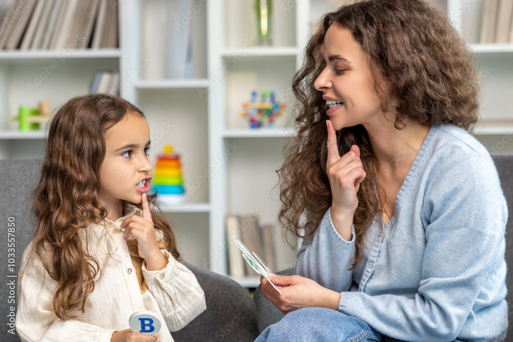 Cute long-haired girl having speech therapy session with the doctor Cute long-haired girl having speech therapy session with the doctor