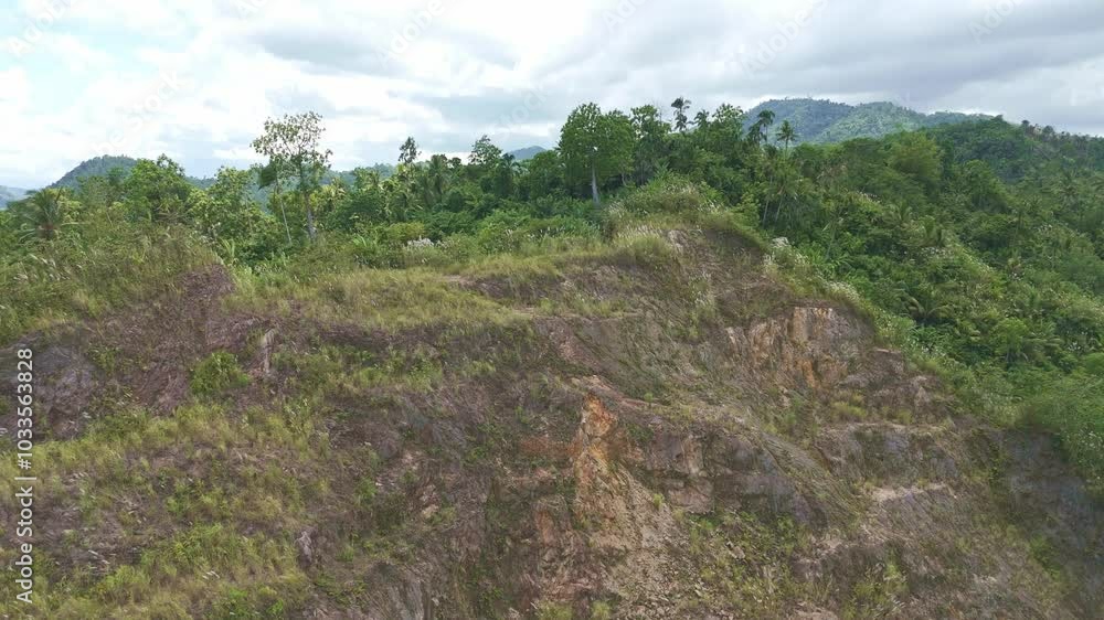 Aerial establishing overview of a disused strip mining quarry for sand and gravel in Surigao City, Philippines, with barren land and sparse trees Aerial establishing overview of a disused strip mining quarry for sand and gravel in Surigao City, Philippines, with barren land and sparse trees