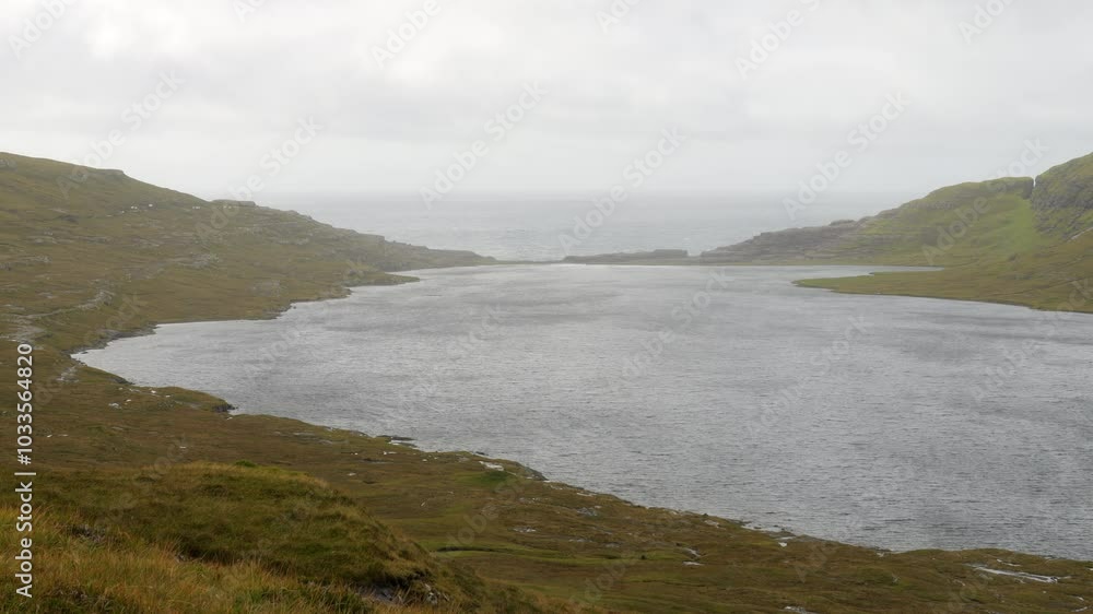 Lake Sorvagsvatn with ocean in background on cloudy day, Faroe Islands. Static Lake Sorvagsvatn with ocean in background on cloudy day, Faroe Islands. Static