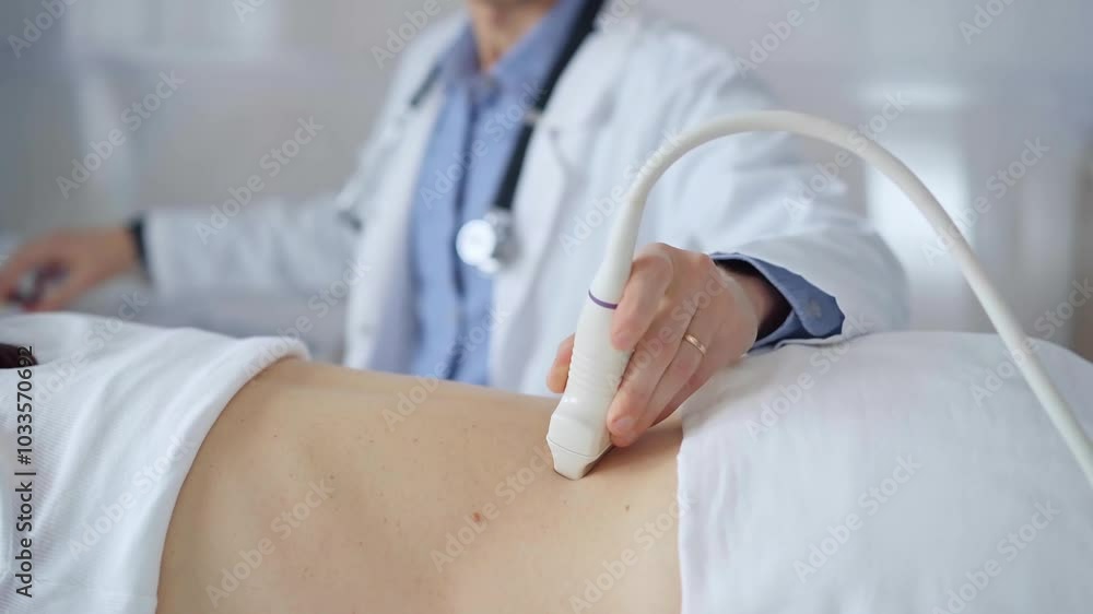 Doctor man using ultrasound equipment on the back of a patient, woman analyzing the results on a monitor in the background. Medicine and science Doctor man using ultrasound equipment on the back of a patient, woman analyzing the results on a monitor in the background. Medicine and science
