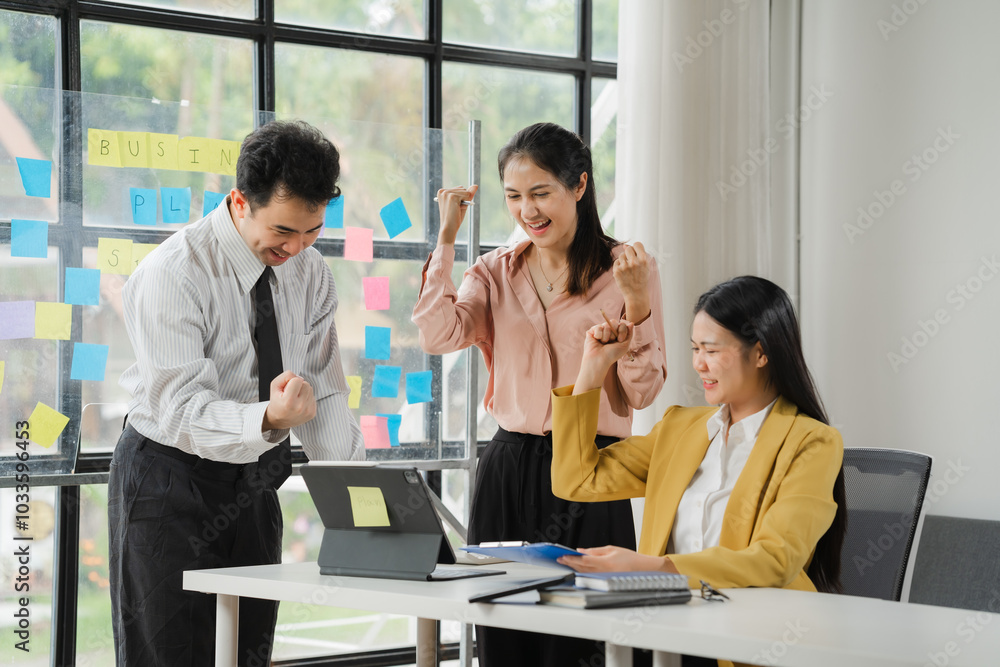 Business Success Celebration: A team of three diverse professionals celebrates their achievement, with fists raised in victory, showcasing their shared joy and success in a modern office setting. Business Success Celebration: A team of three diverse professionals celebrates their achievement, with fists raised in victory, showcasing their shared joy and success in a modern office setting.