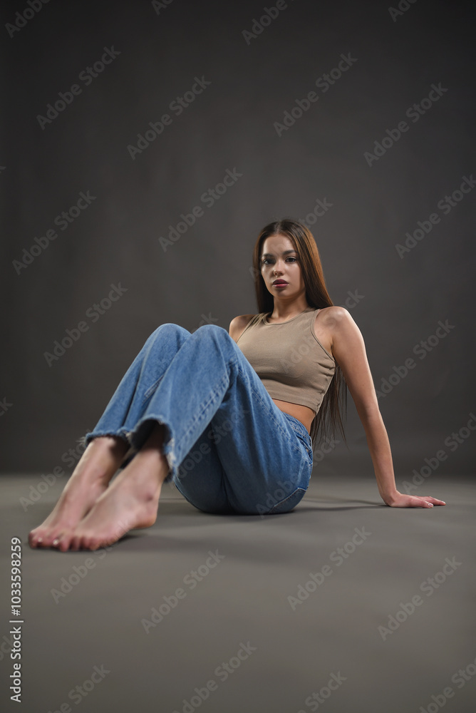 Beautiful girl posing on a gray background. Beauty and fashion. Beautiful girl posing on a gray background. Beauty and fashion.