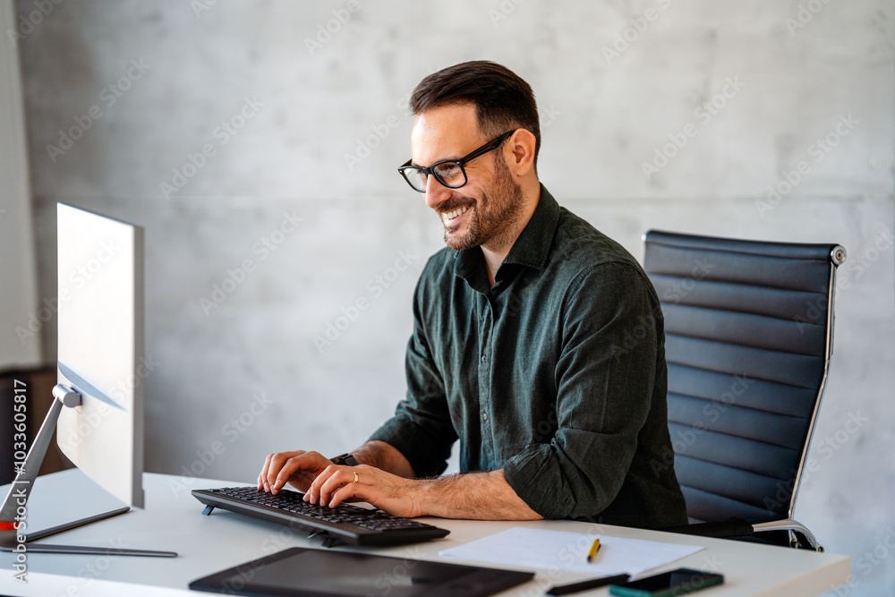Successful busy professional business man working on computer sitting at desk. Successful busy professional business man working on computer sitting at desk.
