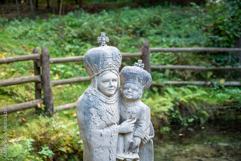 Figure of Holy Mary holding Baby Jesus Christ in wayside shrine on water in Siedliska, Poland Figure of Holy Mary holding Baby Jesus Christ in wayside shrine on water in Siedliska, Poland