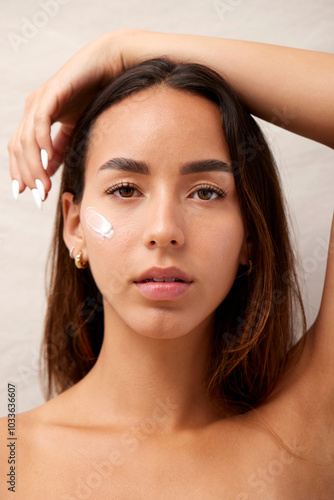 Woman applying facial cream for skincare routine photo