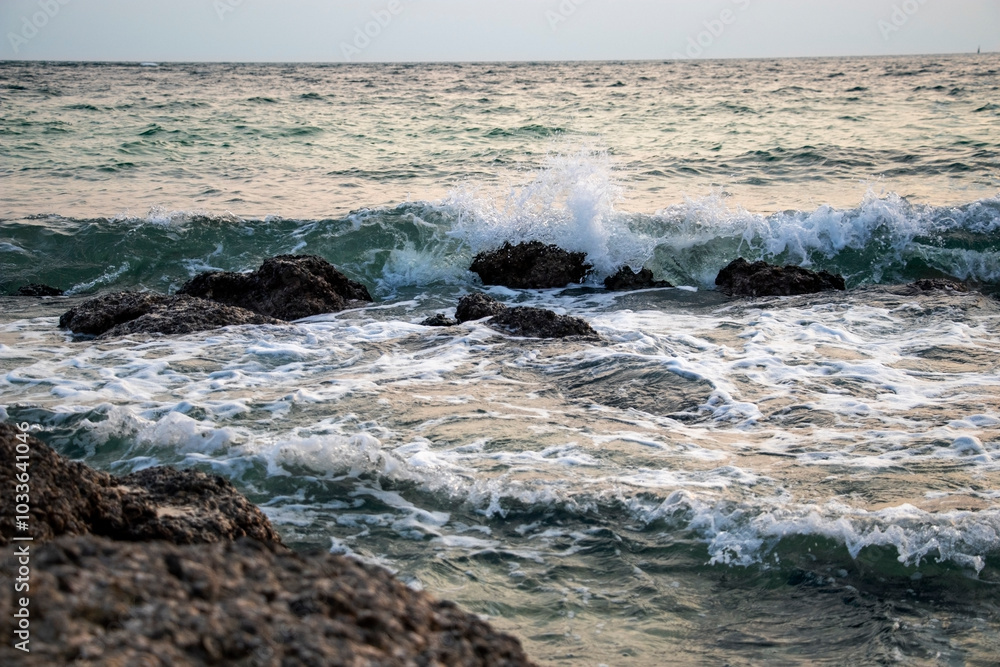 water breaks on rocks in the sea near the shore water breaks on rocks in the sea near the shore