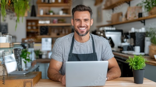 A friendly barista sits behind the counter of a modern café, using a laptop while surrounded by lush greenery and natural light, fostering a relaxing environment.