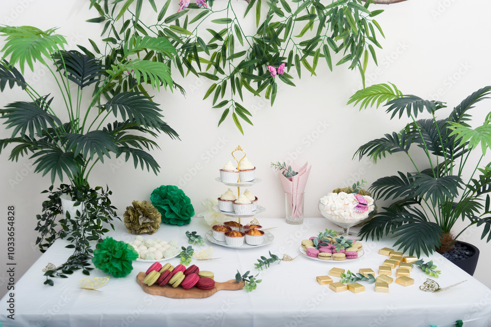 Obraz premium Sweet holiday table with tasty cupcakes with cream with green plants decoration