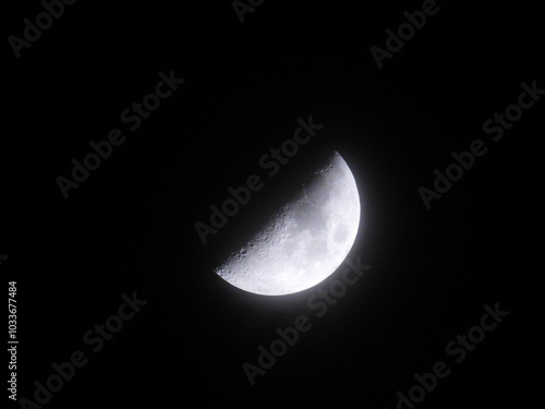 moon in the first quarter phase seen through the mist