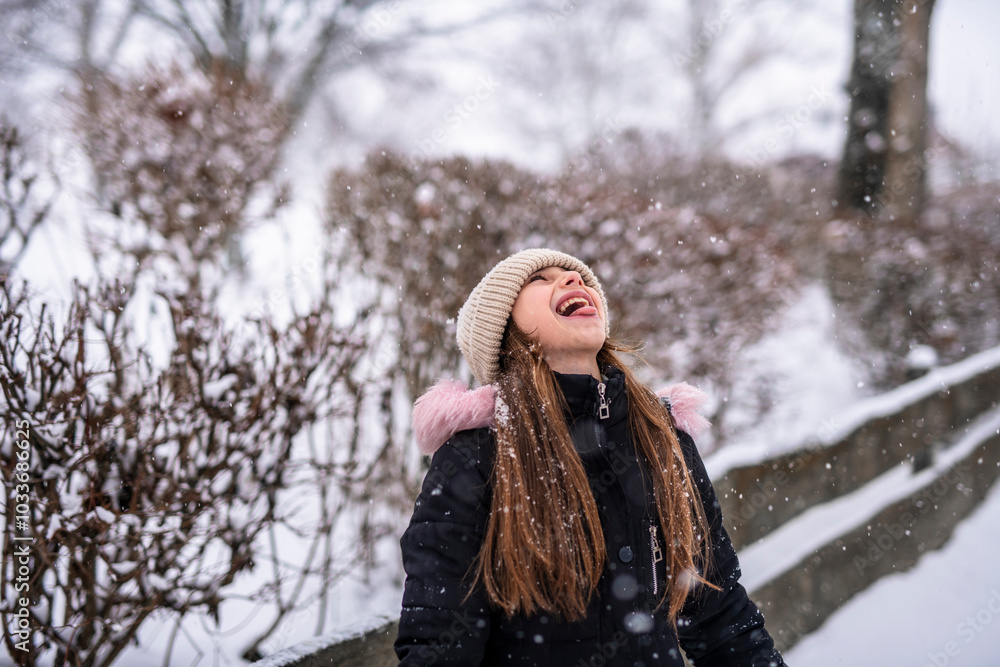A joyful young girl is playing in a winter wonderland A joyful young girl is playing in a winter wonderland