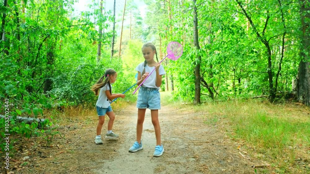 Two little sisters catching butterflies and bugs with their scoop-nets on beautiful sunny summer day Two little sisters catching butterflies and bugs with their scoop-nets on beautiful sunny summer day