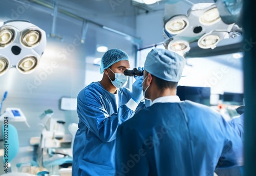 Two surgeons in a sterile operating room, one examining the other's eye with a medical instrument.