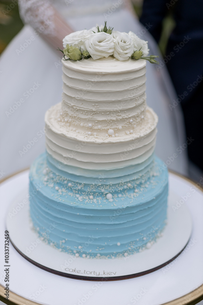 beautiful wedding cake near the arch with flowers in the evening beautiful wedding cake near the arch with flowers in the evening