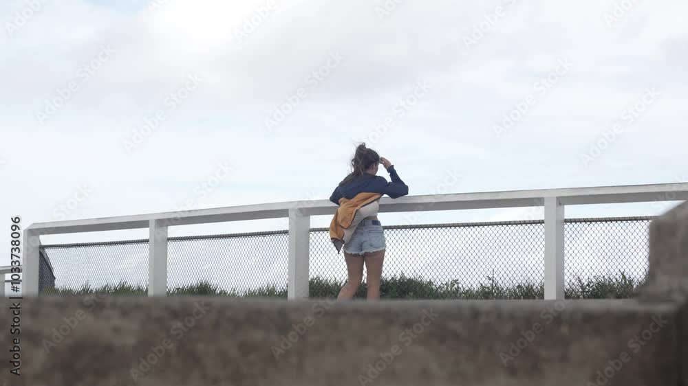 Young brunette woman at viewpoint in Byron Bay Australia, hair in the wind Young brunette woman at viewpoint in Byron Bay Australia, hair in the wind