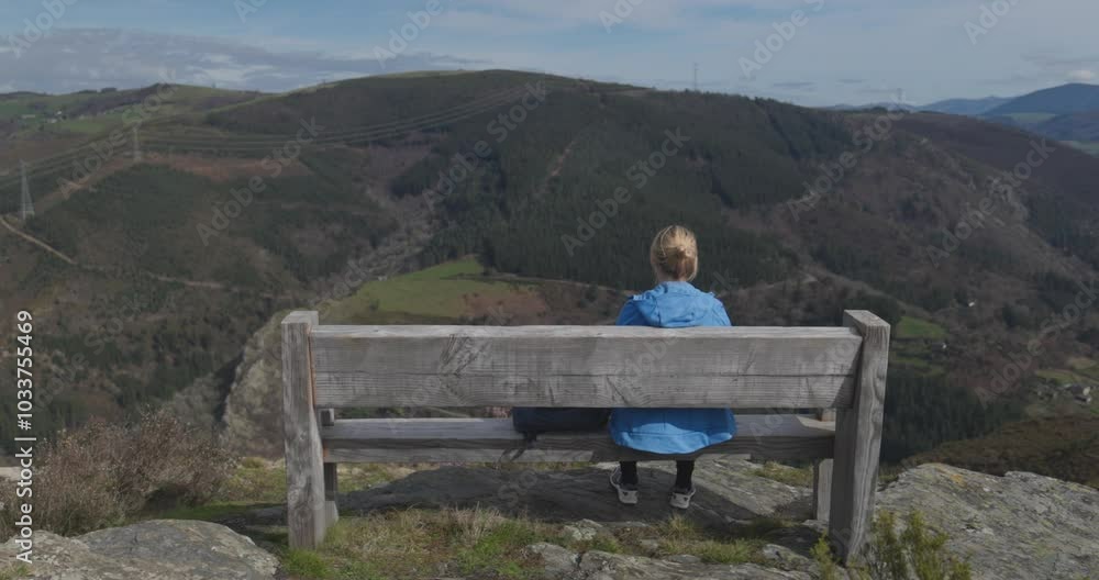 Young woman sitting on wood bench and enjoying mountain view after hiking day - Nature, travel and sport concept Young woman sitting on wood bench and enjoying mountain view after hiking day - Nature, travel and sport concept
