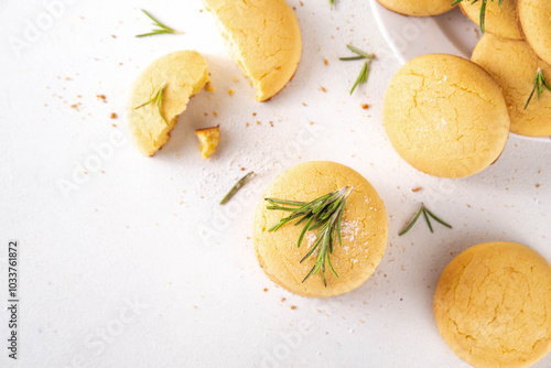 Savory rosemary and lemon shortbread cookies. Salted tasty cheese cookie appetizers with ingredients for cooking on white kitchen table photo