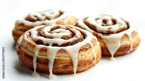 Freshly baked cinnamon rolls glisten with dripping white icing on a bright white background, capturing the golden brown pastry in close-up with soft shadows and high detail.