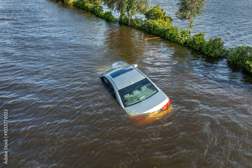 Flooded road with sunken car in surrounded with water Florida residential area. Consequences of hurricane Debby natural disaster photo