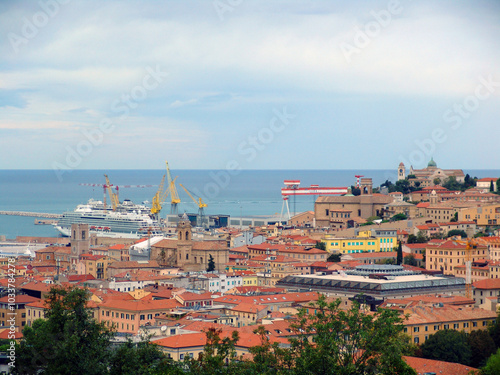 View of the harbor in the Italian city of Ancona. Historic architecture and trees are visible in the foreground