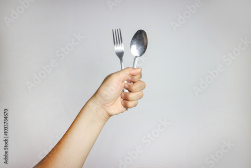 A women hand holding spoon silver stainless steel. Isolated in White Background. side View.
