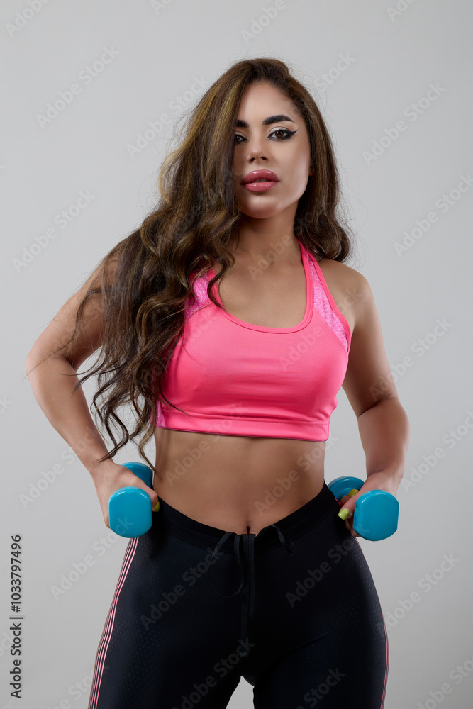 beautiful woman working out with dumbbells, isolated on gray background beautiful woman working out with dumbbells, isolated on gray background