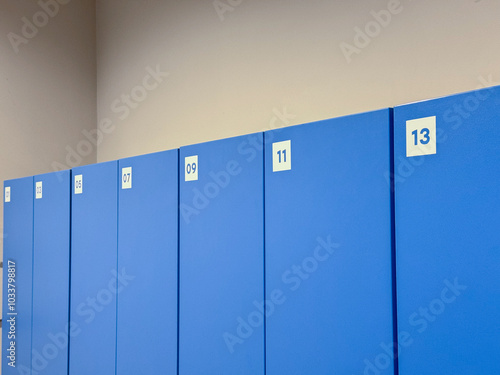 A row of blue lockers numbered 1 through 13 in a clean and organized locker room photo