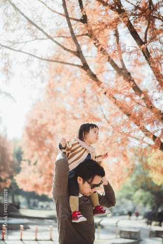 紅葉の木と肩車される女の子