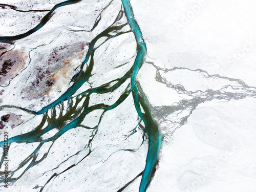 фотографія An aerial view of winding streams and river channels cutting through a barren landscape